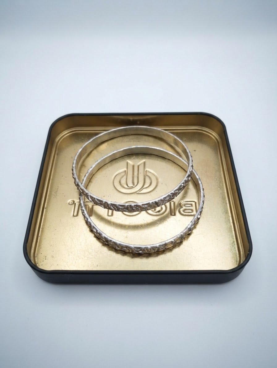 Deux bracelets jonc argentés se distinguent par leur élégant motif ciselé en relief
