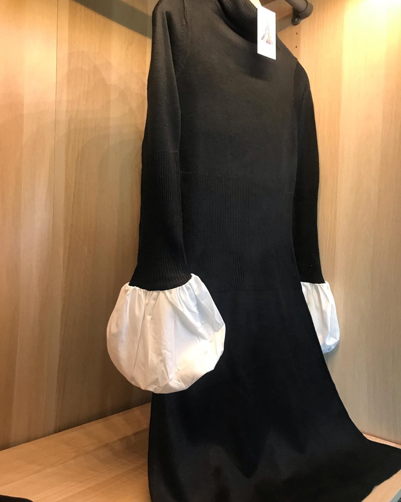 Robe pull noire à col roulé avec des manches blanches à volants