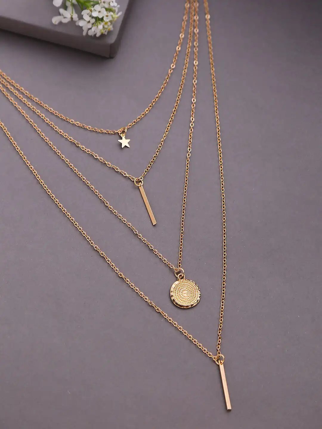 Collier multicouche (kaskad) doré composé de plusieurs chaînes fines et de plusieurs pendentifs assortis