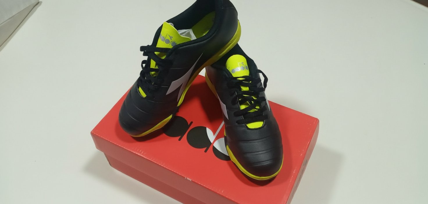 Des chaussures demi-crampon Diadora Pichichi 3 TF Jr en noir et jaune. 