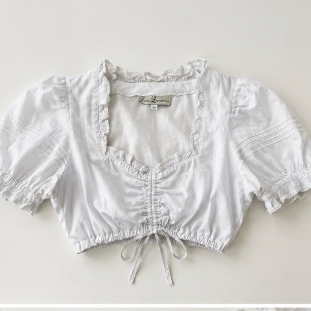 White Lisa's Landhaus dirndl crop top featuring a charming ruched neckline and puffed sleeves.
