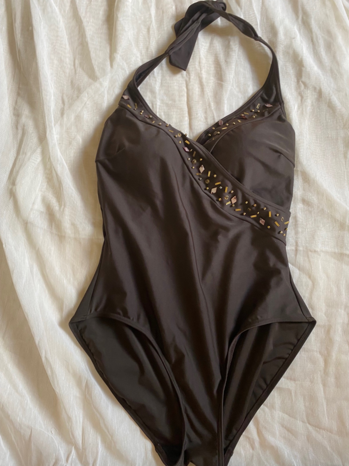 Un maillot de bain une pièce marron avec des perles décoratives, fabriqué par la marque de prêt-à-porter F&F (Florence & Fred) est une marque de mode britannique d'envergure internationale