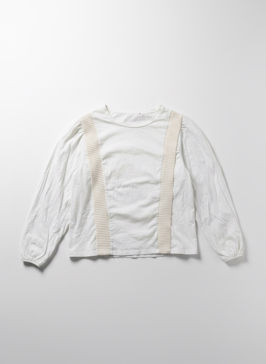 Blouse blanche à manches longues bouffantes et détails côtelés