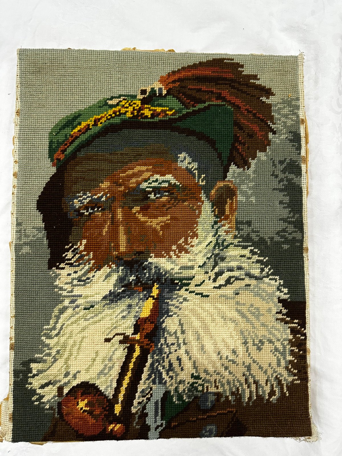 Tableau brodé à la main représentant un homme avec pipe. Bon état, idéal pour décoration.
