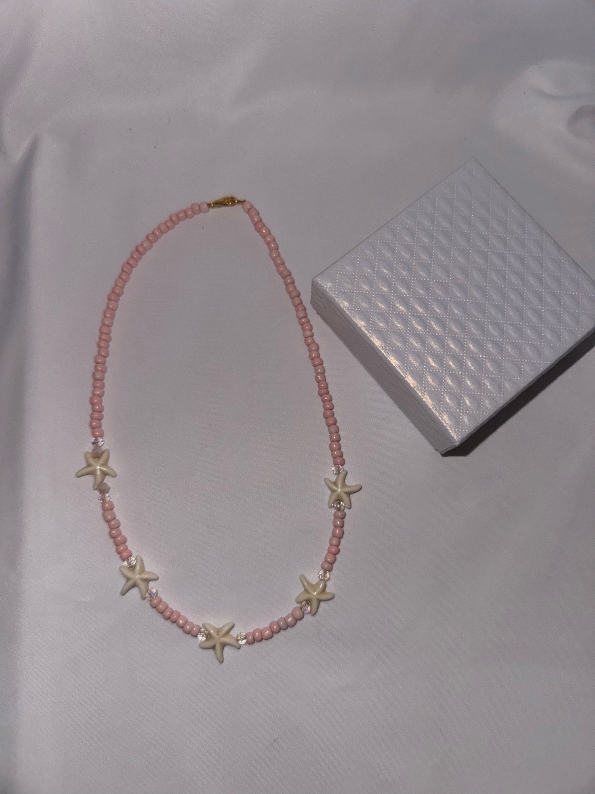 Collier de perles roses avec étoiles de mer