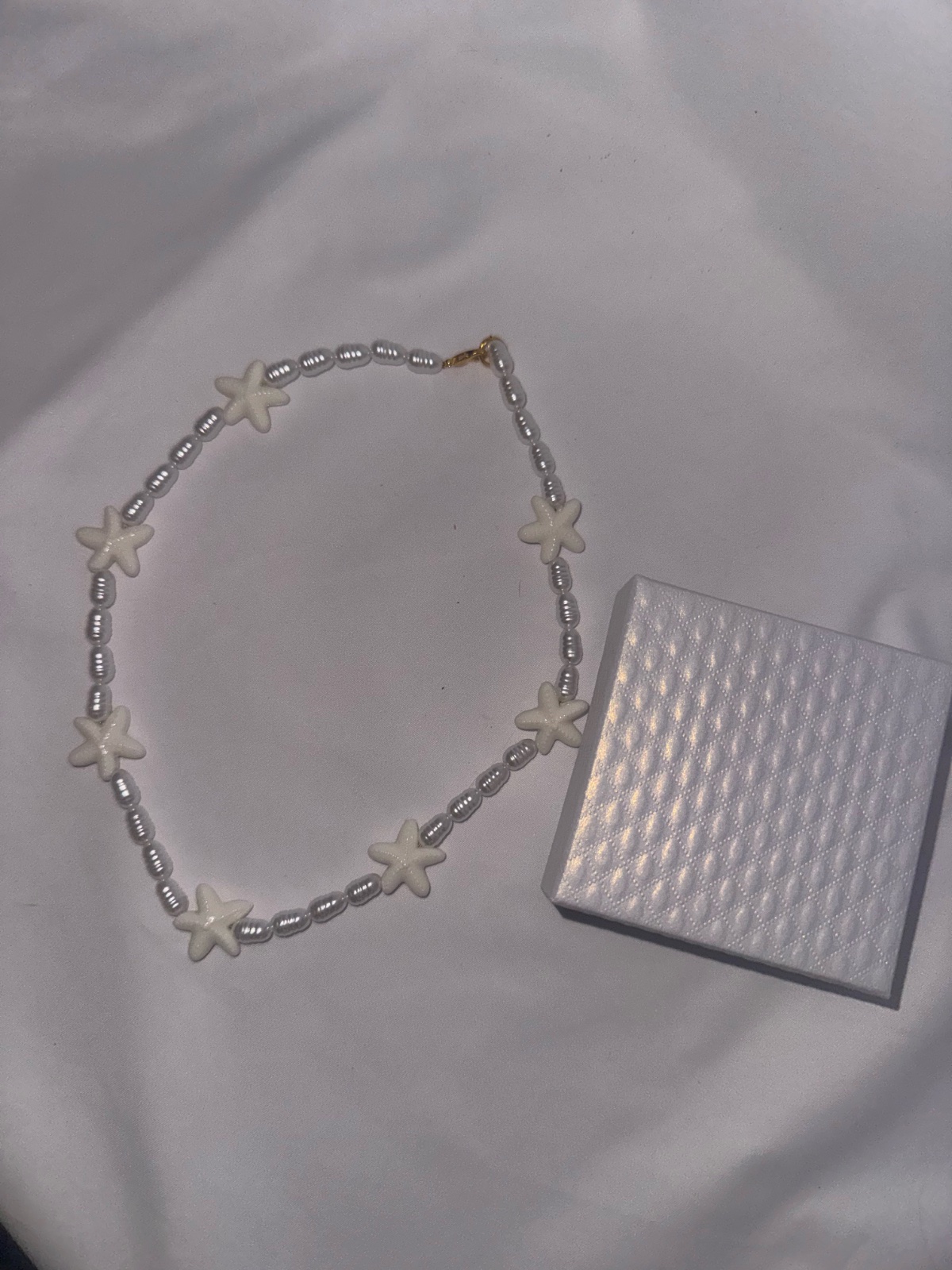 Collier de perles blanches et étoiles de mer