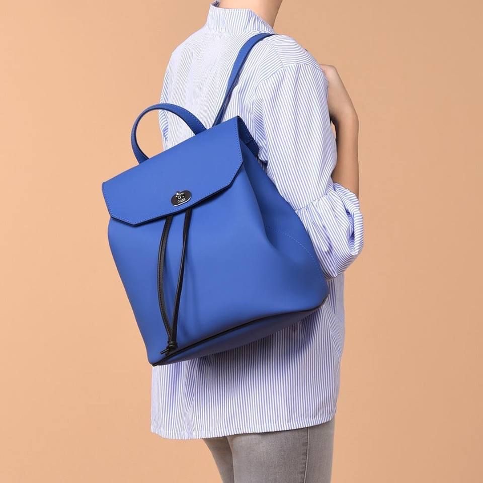 Authentique ...C'est un sac à dos bleu vif avec un rabat et un cordon de serrage noir, ressemblant au modèle O bag Soft / O bag Ride