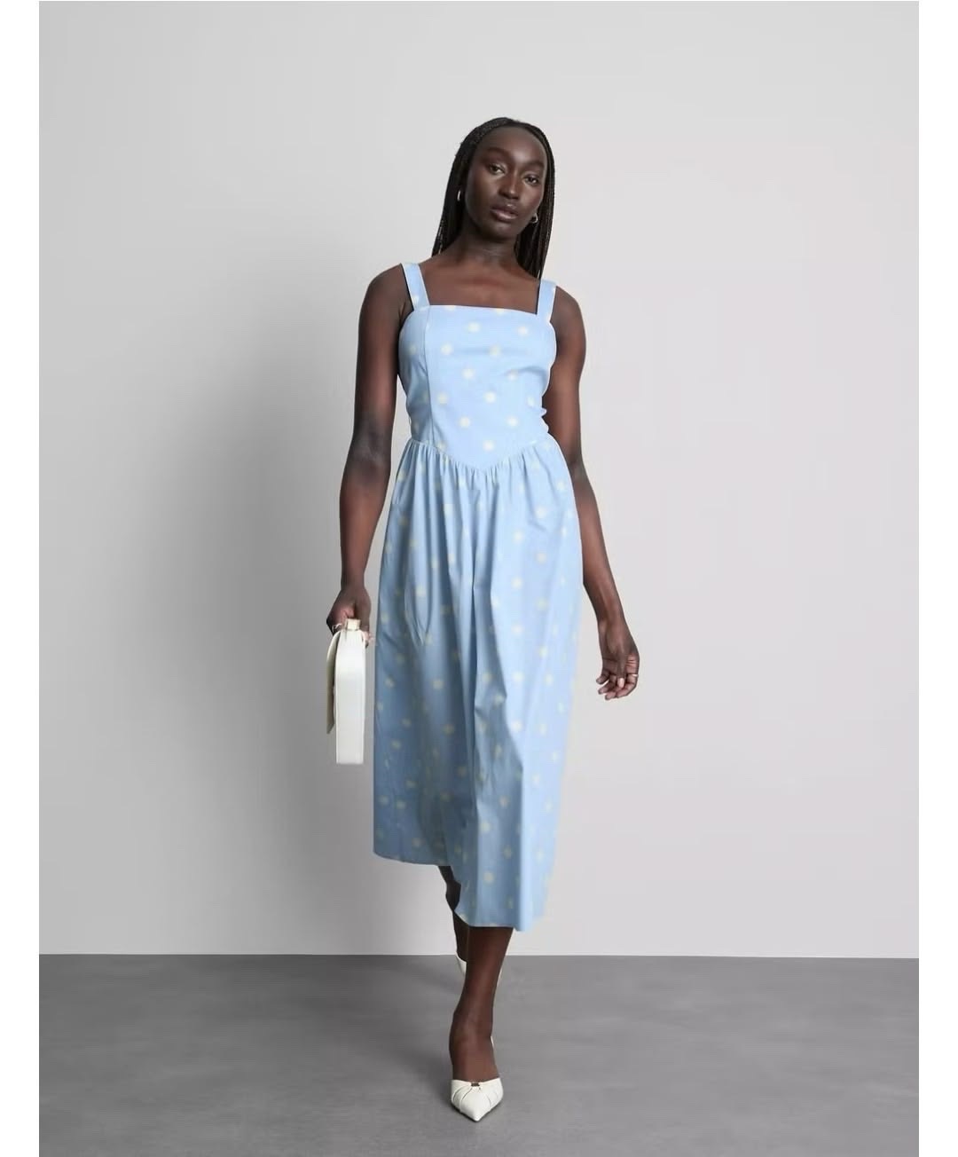 Cette robe midi Primark présente une encolure carrée de style corset dans un motif à pois bleus.