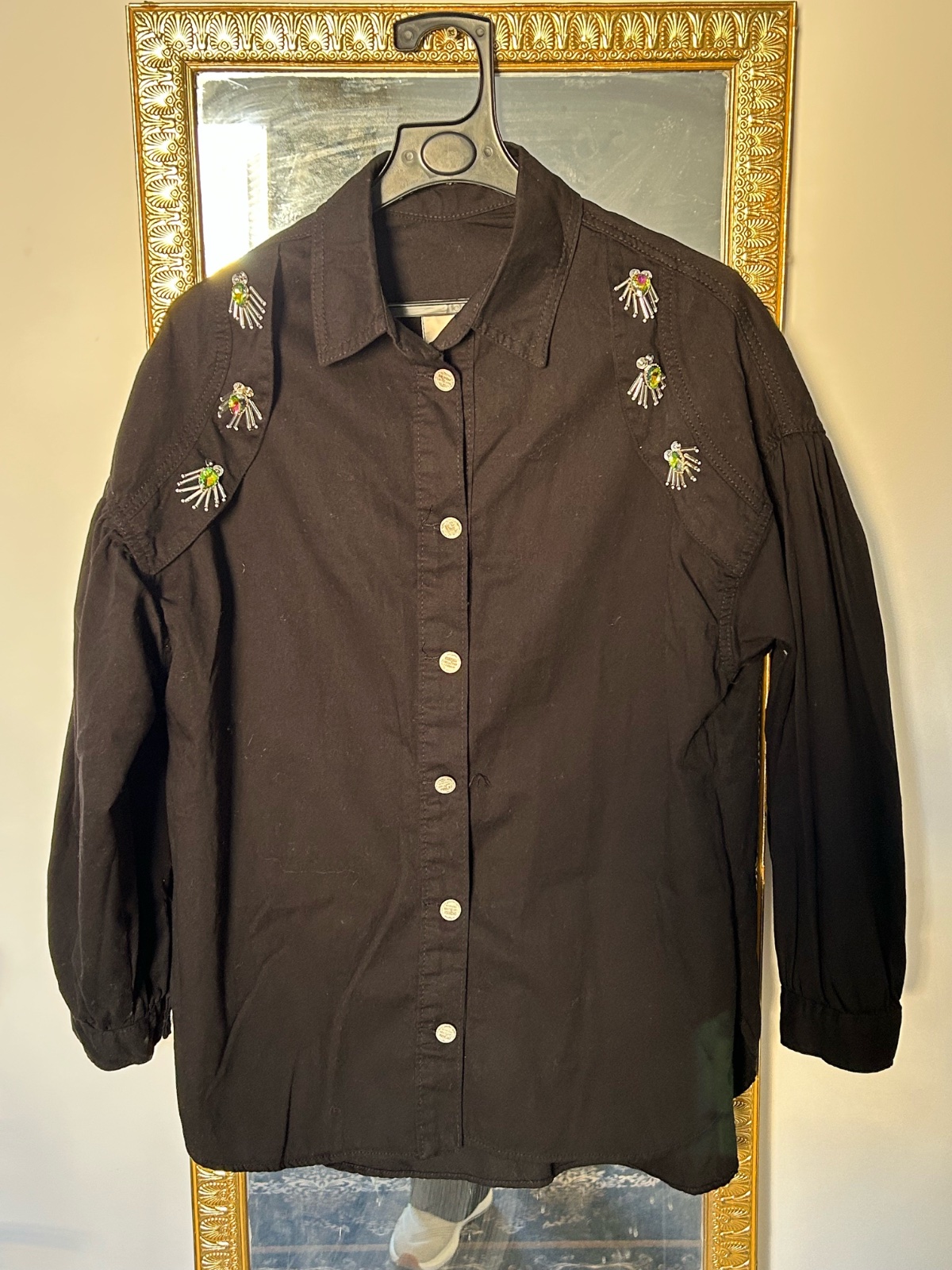 Une chemise noire à manches longues avec broderies colorées sur les épaules et la poitrine