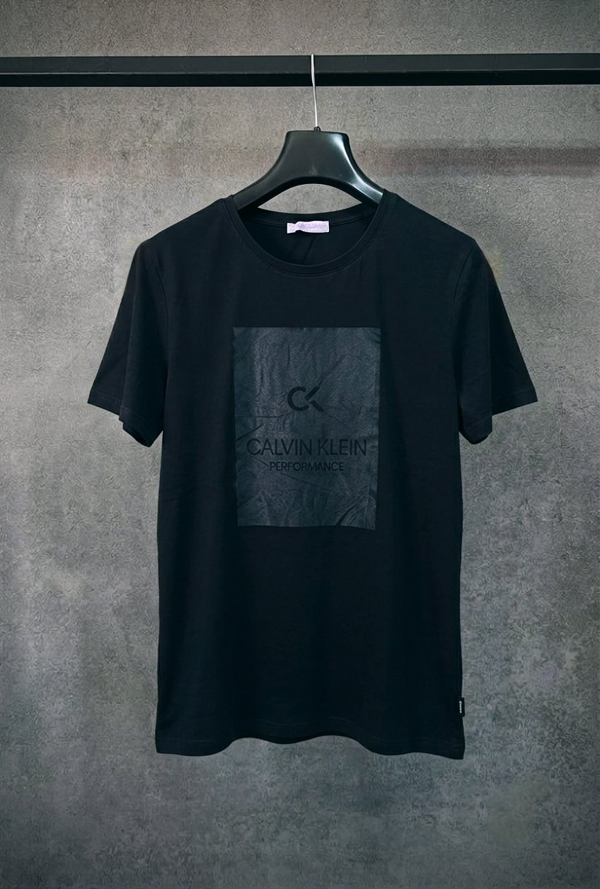 Ce t-shirt noir à col rond présente un empiècement carré ton sur ton sur la poitrine affichant le logo « CK Calvin Klein Performance ».    