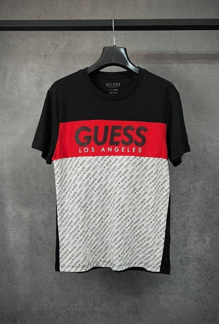 Ce t-shirt Guess noir à bande rouge arbore un empiècement inférieur imprimé et le logo contrasté « Guess Los Angeles » sur la poitrine.   