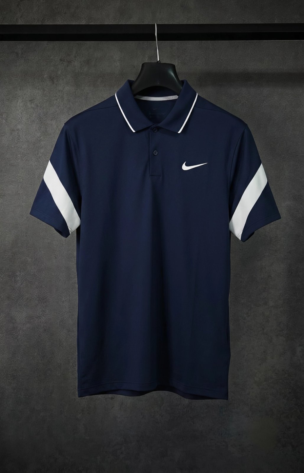 Ce polo est un modèle Nike Golf MM Fly Framing Commander bleu marine avec des bandes blanches contrastantes sur les manches