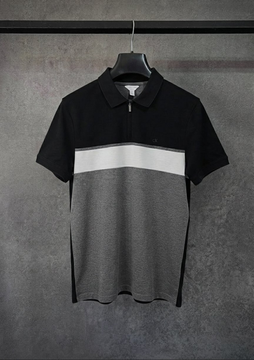Ce polo Calvin Klein noir et gris à manches courtes arbore un design élégant en blocs de couleurs et un col zippé.