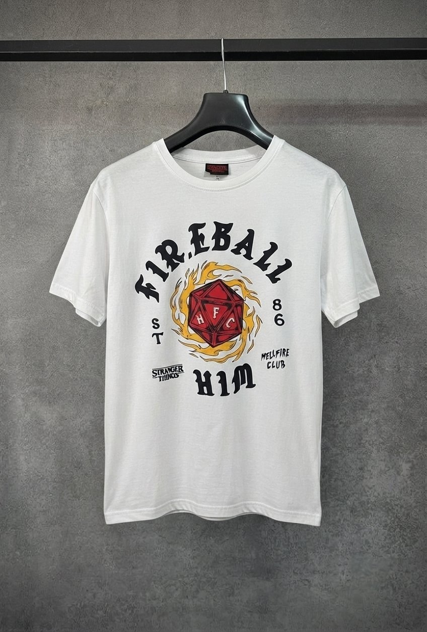 Ce t-shirt blanc en coton présente un graphisme officiel inspiré de la série Stranger Things (Netflix), mettant en avant le club de Donjons et Dragons de Hawkins, le Hellfire Club, avec l'inscription "Fireball Him" et un dé à 20 faces enflammé
