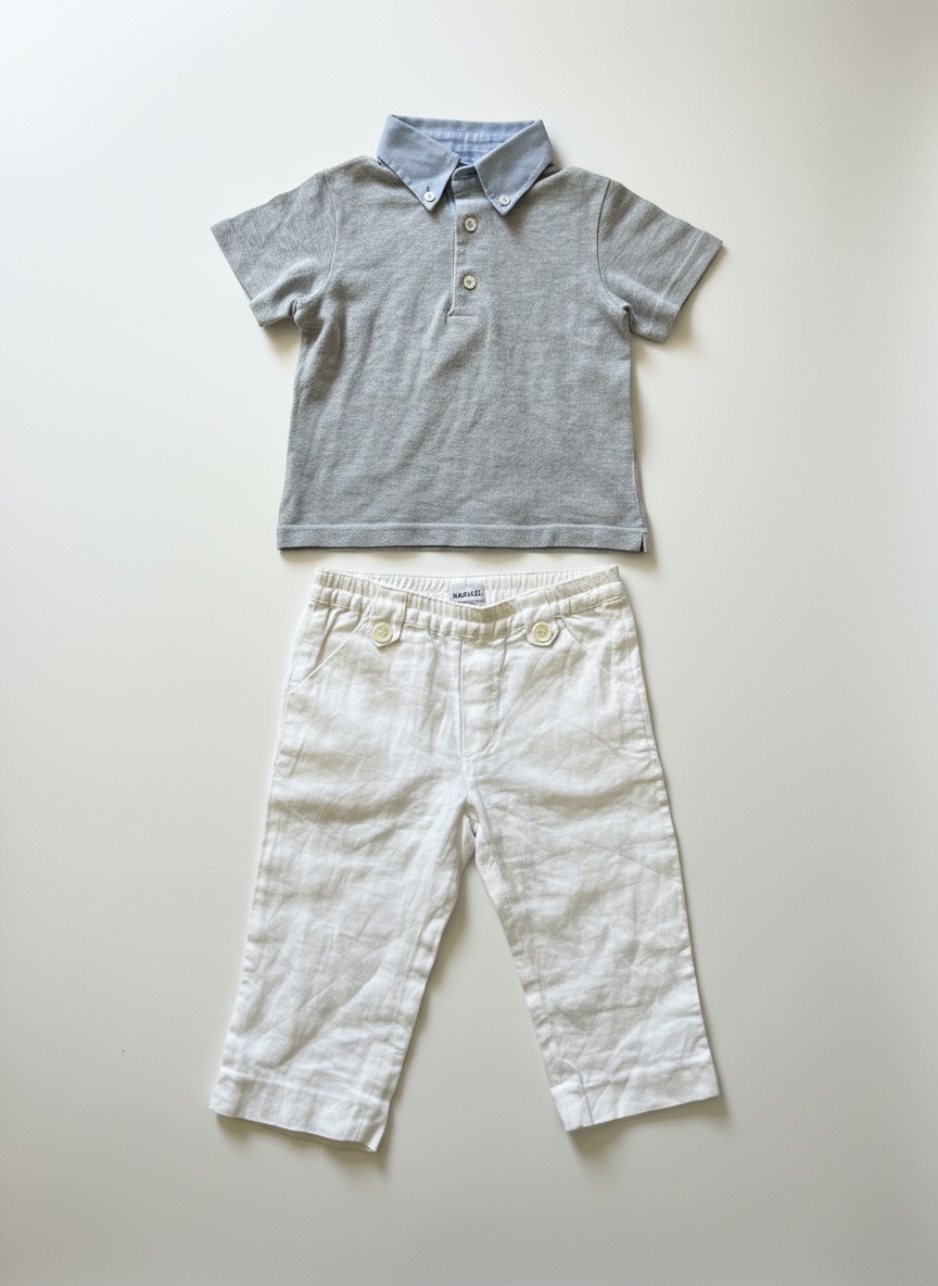 A charming baby boy clothing set features a short-sleeved grey knit polo shirt paired with classic white linen trousers.