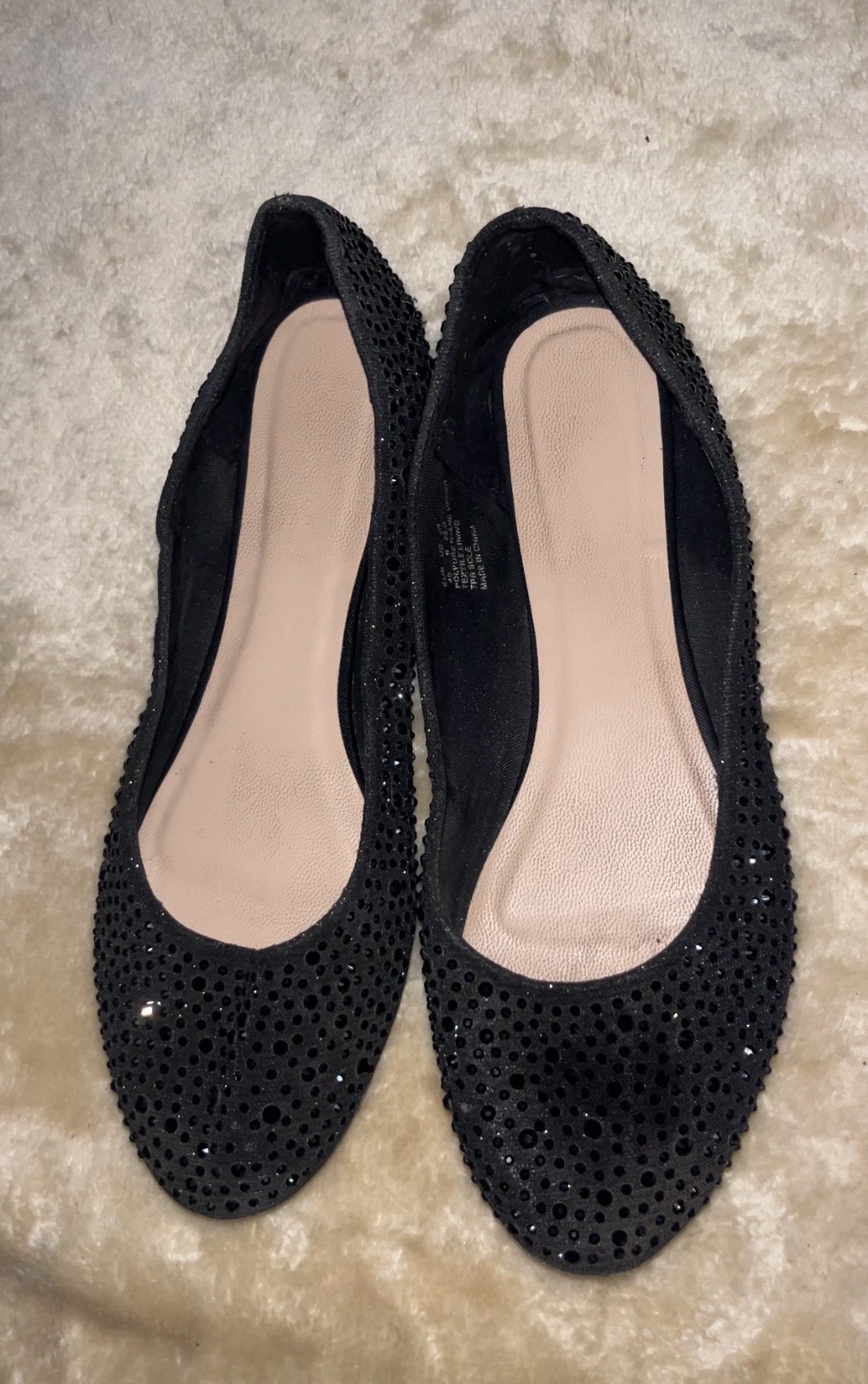 A black ballet flatsfeature a sparkling rhinestones