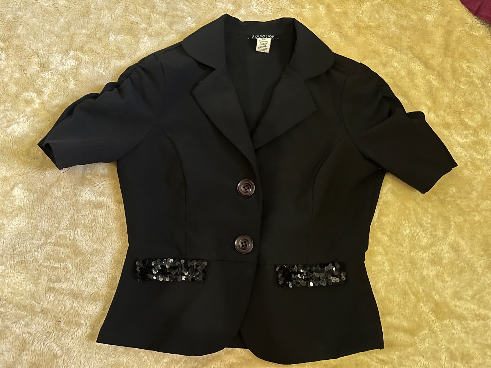 Black short-sleeve blazer featuring sequin detailing on the pockets
