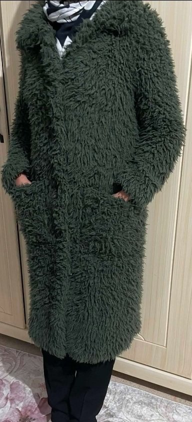 Long manteau vert sapin présente une texture duveteuse en fausse fourrure shaggy, doté de larges revers et de grandes poches plaquées sur le devant.