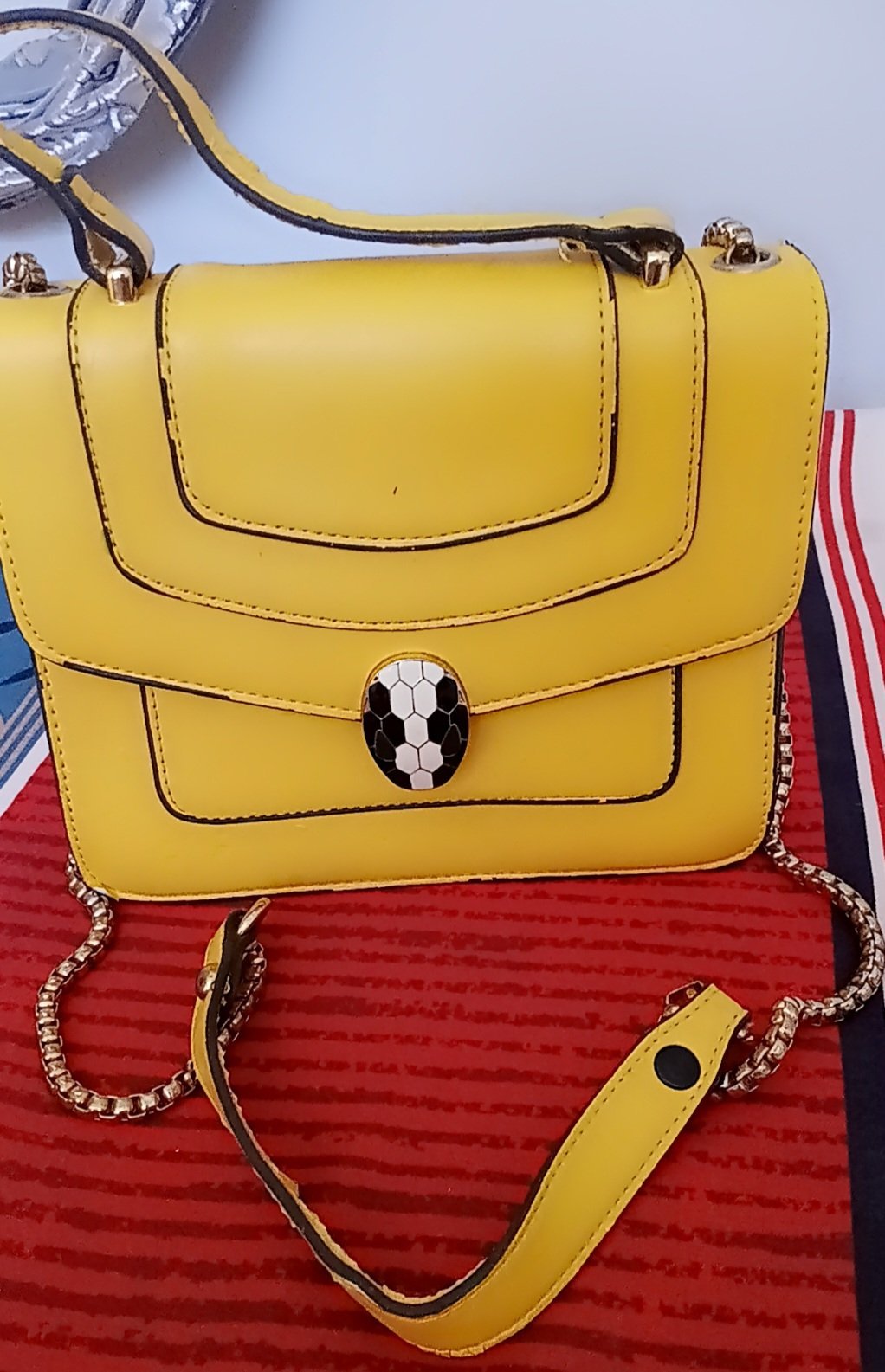 Sac à main jaune ressemble au modèle Serpenti Forever de Bvlgari, reconnaissable à son fermoir iconique en forme de tête de serpent