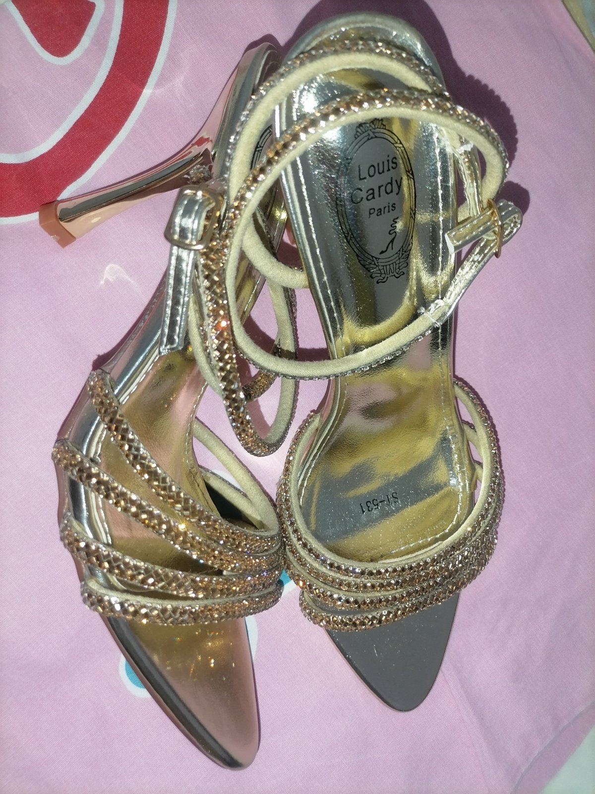 Paire de sandales à talons aiguilles élégantes et scintillantes, dans un style festif et glamour.