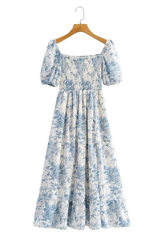 Robe longue romantique à imprimé floral bleu et blanc, dotée d'un buste smocké à col carré et de manches bouffantes.imprimé toile de jouy