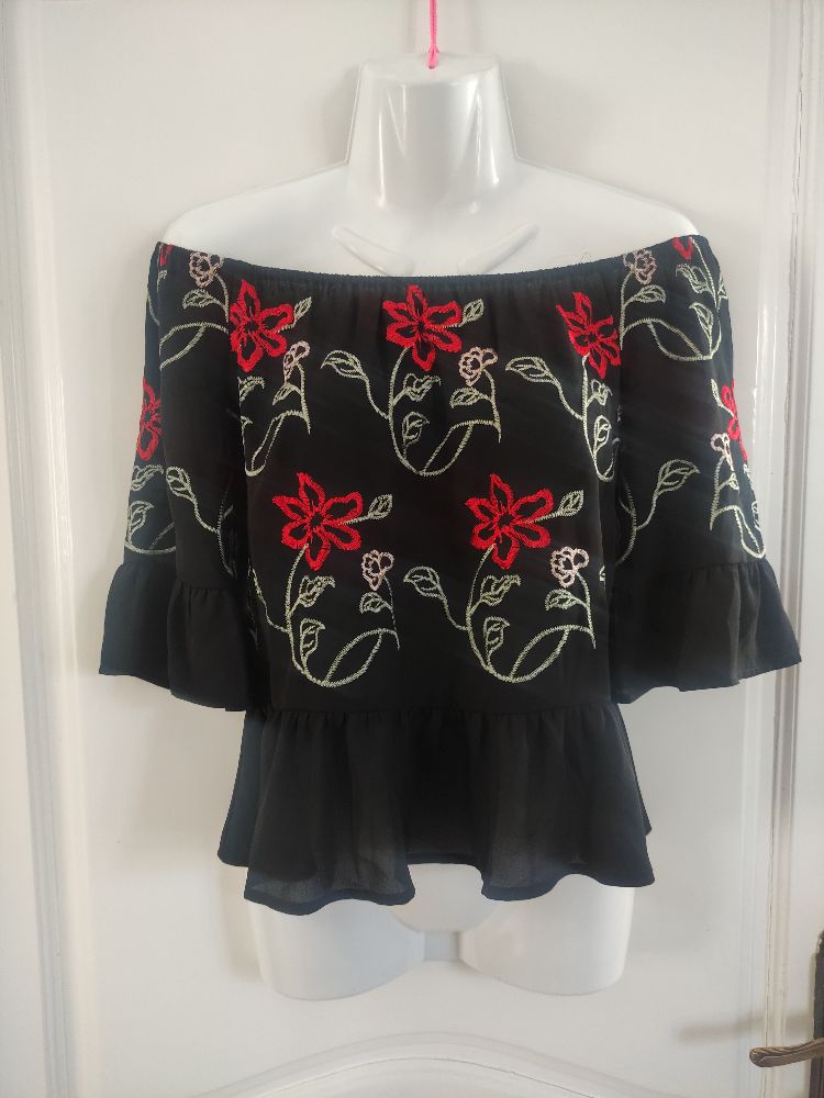 Pull fleurie avec épaules dénudées.