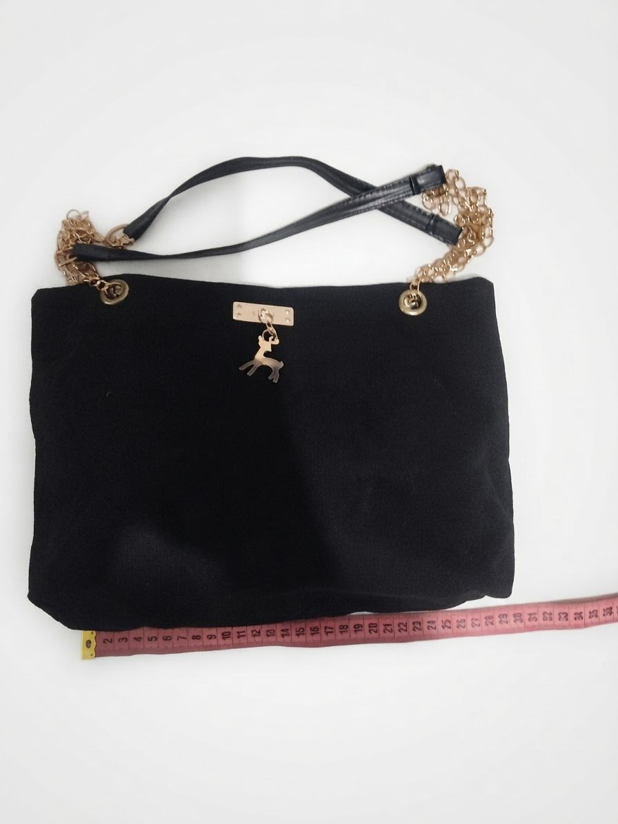 Sac à main noir en tissu léger avec doublure intérieure.