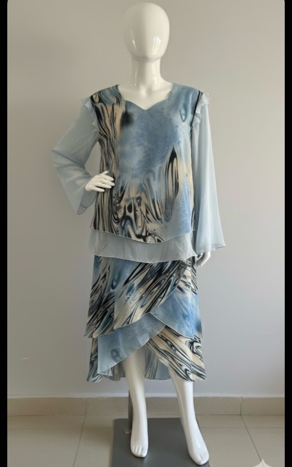 Magnifique ensemble jupe et haut Khadija dans des tons de bleu ciel, noir et beige/crème. Confectionné dans un tissu léger et fluide, idéal pour les occasions spéciales