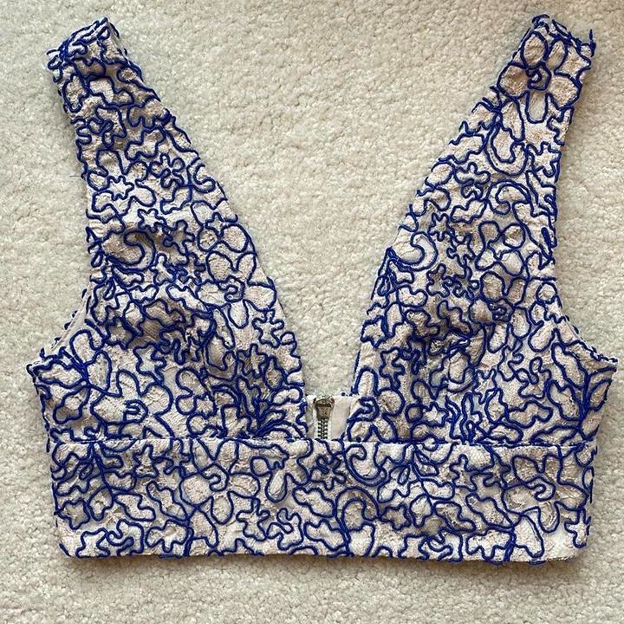 Crop top en dentelle rose poudré avec des motifs brodés en fil bleu marine