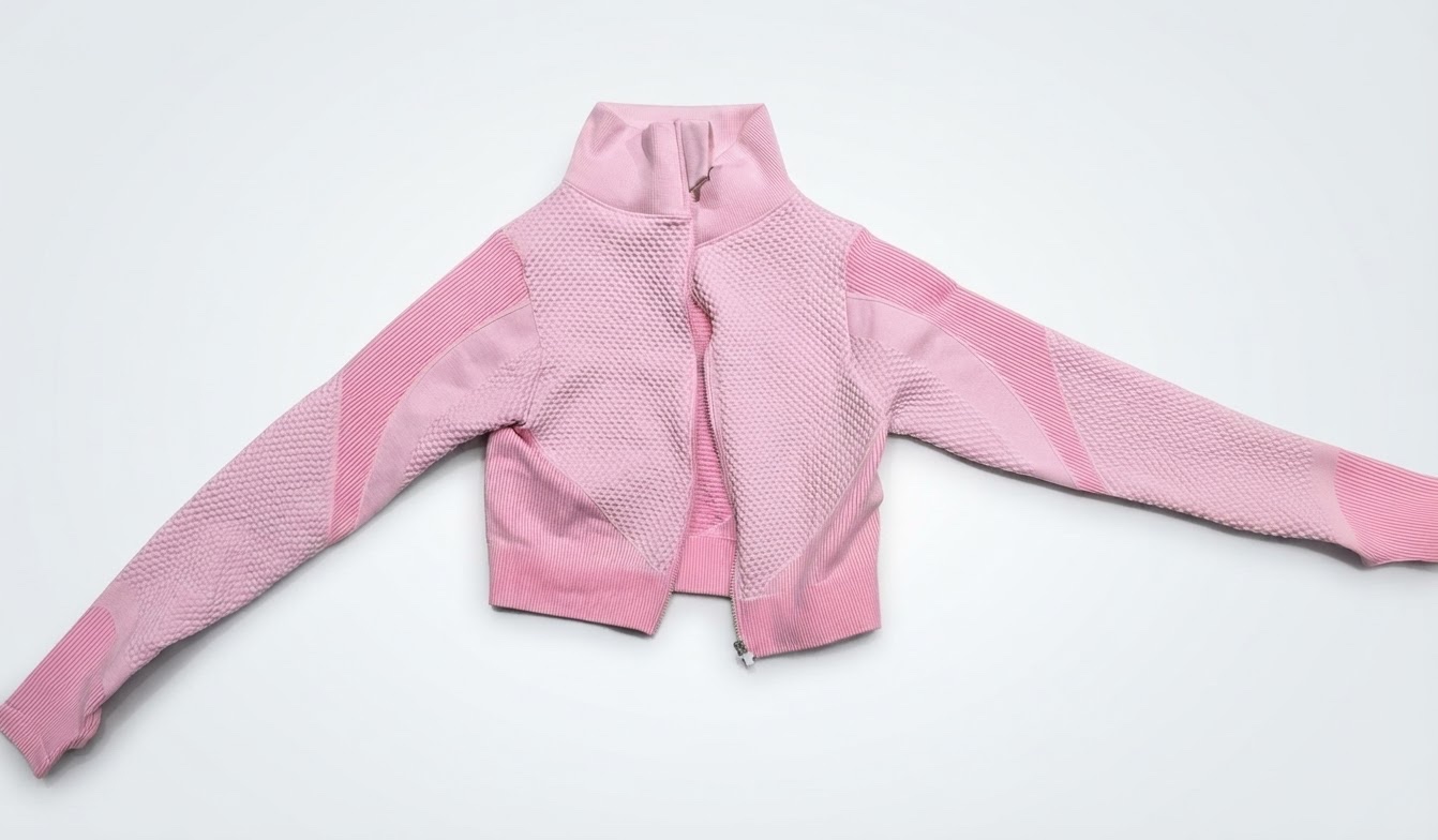 A light pink seamless athletic crop jacket with a mock neck, full front zipper, textured honeycomb or knit panels, and long sleeves Pour sport 