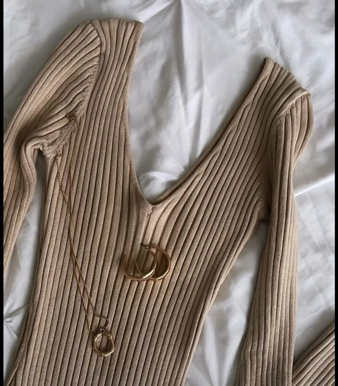 Pull court côtelé à manches longues de couleur taupe ou beige. 