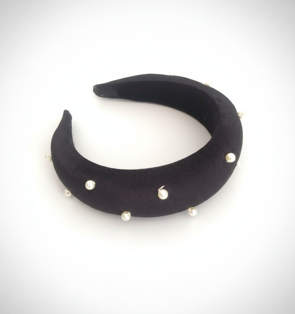 Un serre-tête rembourré noir, orné de perles blanches, fabriqué en satin avec une doublure confortable 