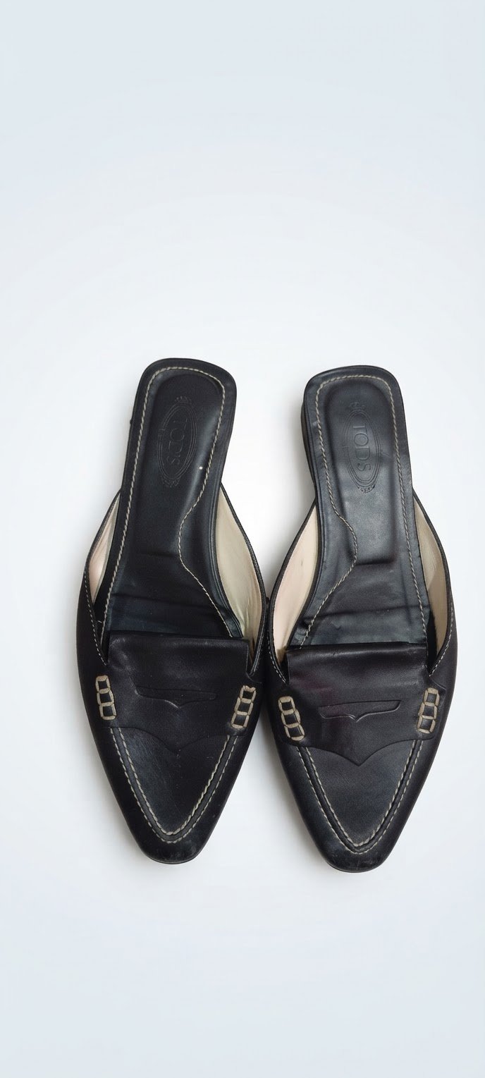 Vintage Tod's black leather loafer mules resting on top of a brown branded Tod's dustbagvintage Tod's black leather loafer mules resting on top of a brown branded Tod's dustbag