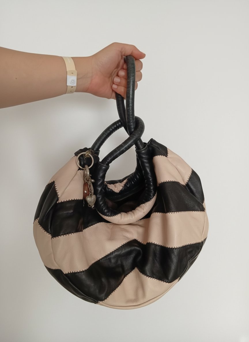 Sac de collectionneur au motif noir et rose, chic et intemporel. Porté de plusieurs façons (à la main, noué, ou les deux anses sur l’épaule). Authentique Sonia Paris, parfait pour un look moderne et élégant.