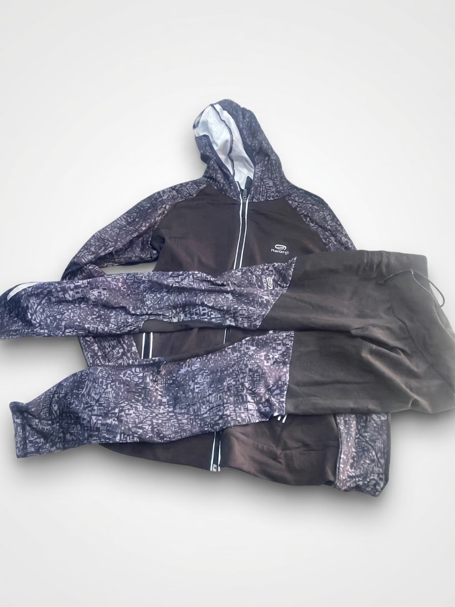 Veste et legging légère de course à pied noire et grise, dotée d'une fermeture éclair intégrale, de poches zippées et de détails réfléchissants.