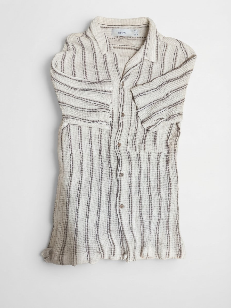  chemise à manches courtes de la marque Bershka, de couleur écru avec des rayures verticales foncées et une texture gaufrée.