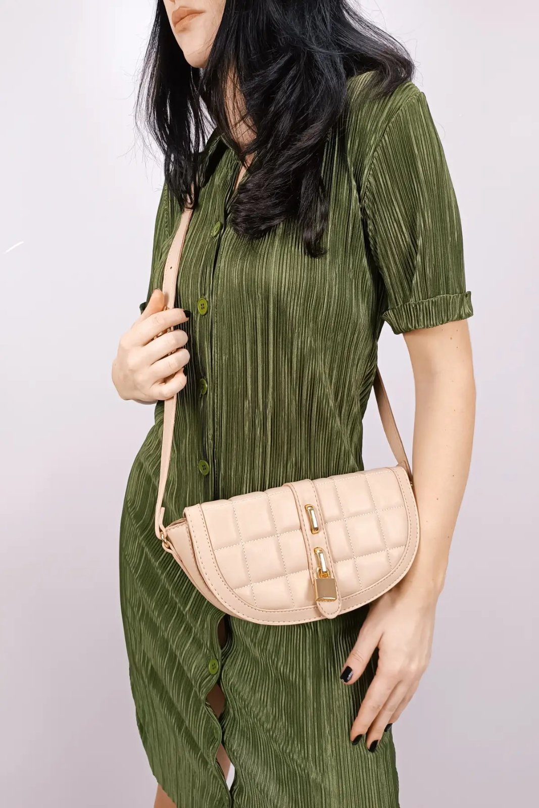 Sac à main beige avec bandoulière structuré avec des coutures matelassées et un fermoir à cadenas, correspondant aux tendances actuelles de luxe discret.