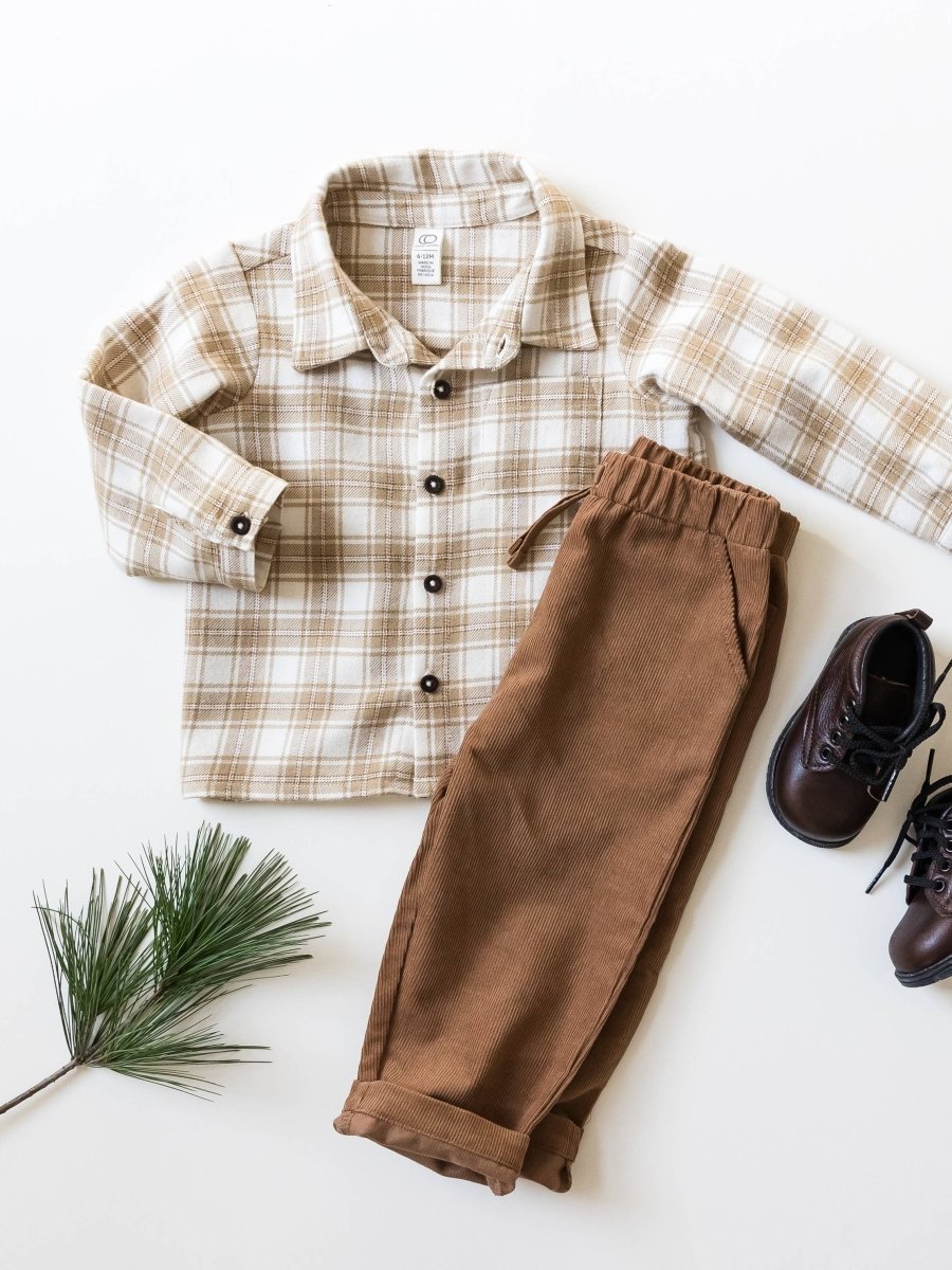 Un ensemble pour bébé composé d'une chemise à manches longues à motif à carreaux beiges et d'un pantalon marron en velours côtelé avec une taille élastique et un cordon de serrage.