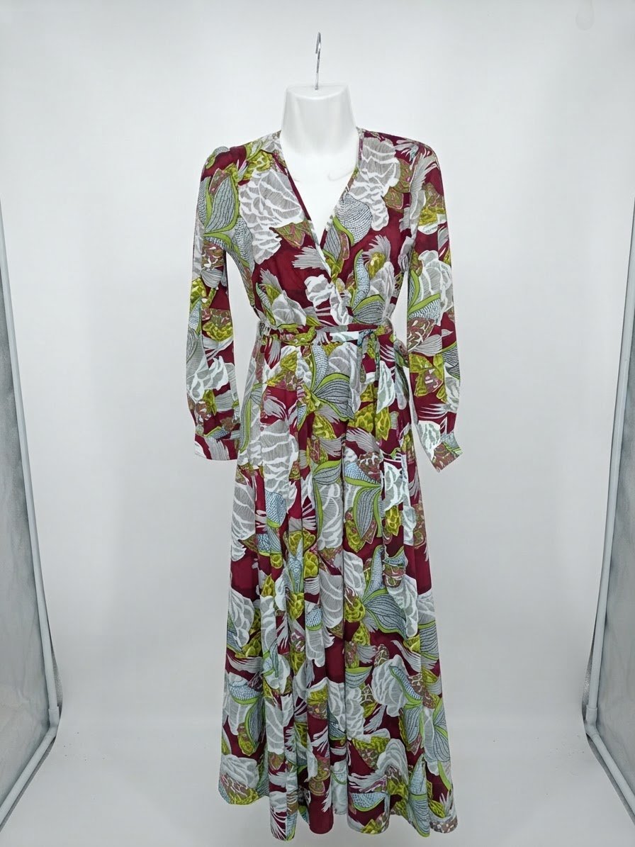 Robe longue présente une coupe portefeuille avec un décolleté en V croisé, des manches longues et une ceinture à nouer à la taille, dans des tons bordeaux, vert olive, blanc et gris à motif floral