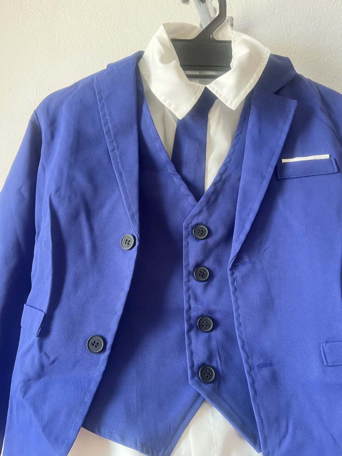 Costume bleu roi, avec chemise blanche, cravate, papillon, et pantalon bleu roi 
