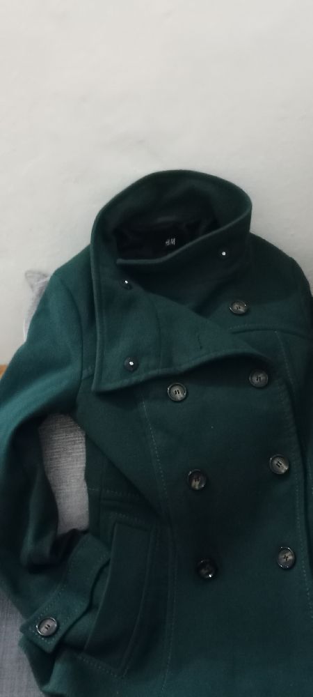 C'est un manteau croisé vert forêt H&M, souvent appelé "pea coat". 