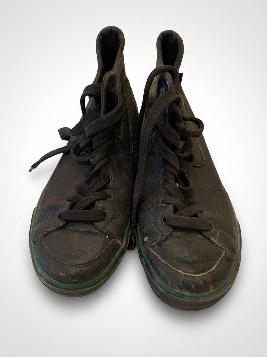     Baskets montantes Nike en cuir noir avec détails verts.
