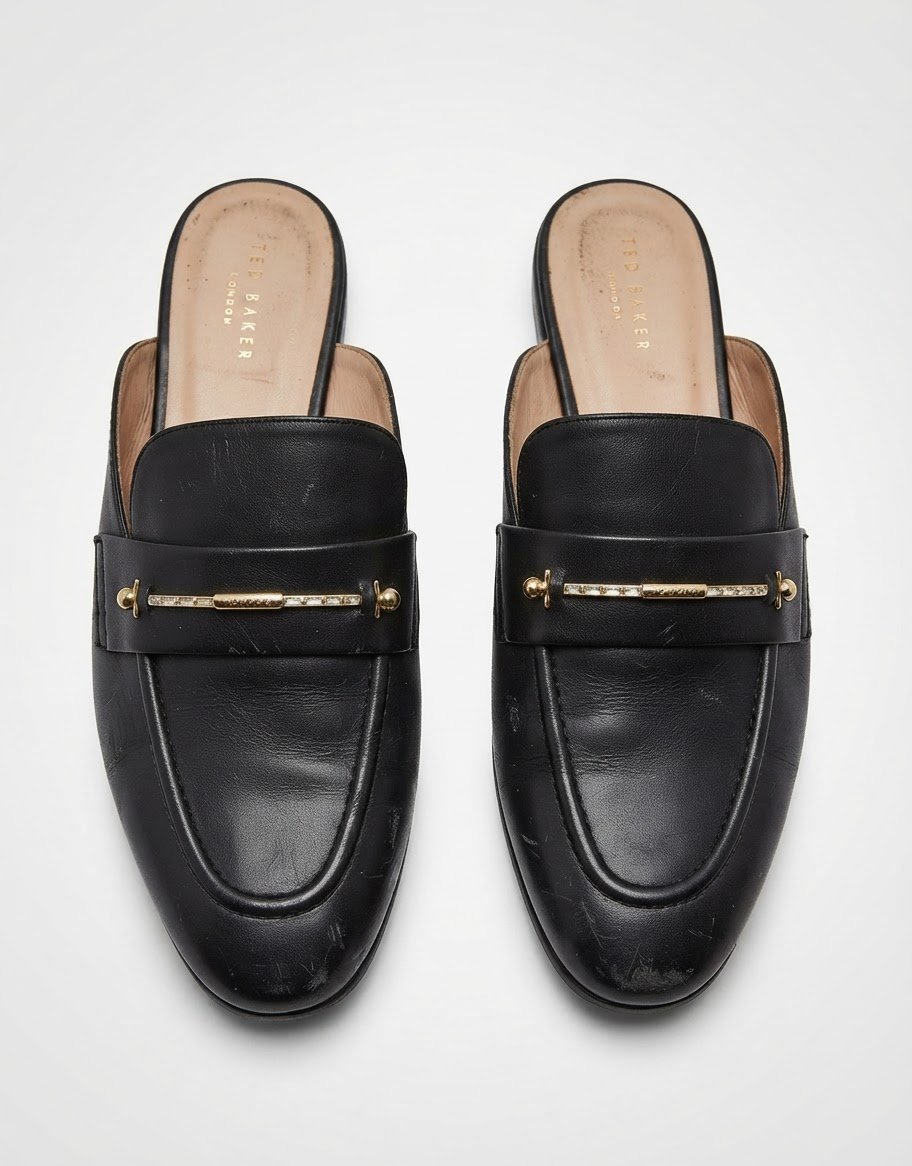 Des mules mocassins en cuir noir Ted Baker London (modèle Zzola Leather Mule Loafers ou Zola Icon Bit Loafer Mule) avec un mors métallique doré