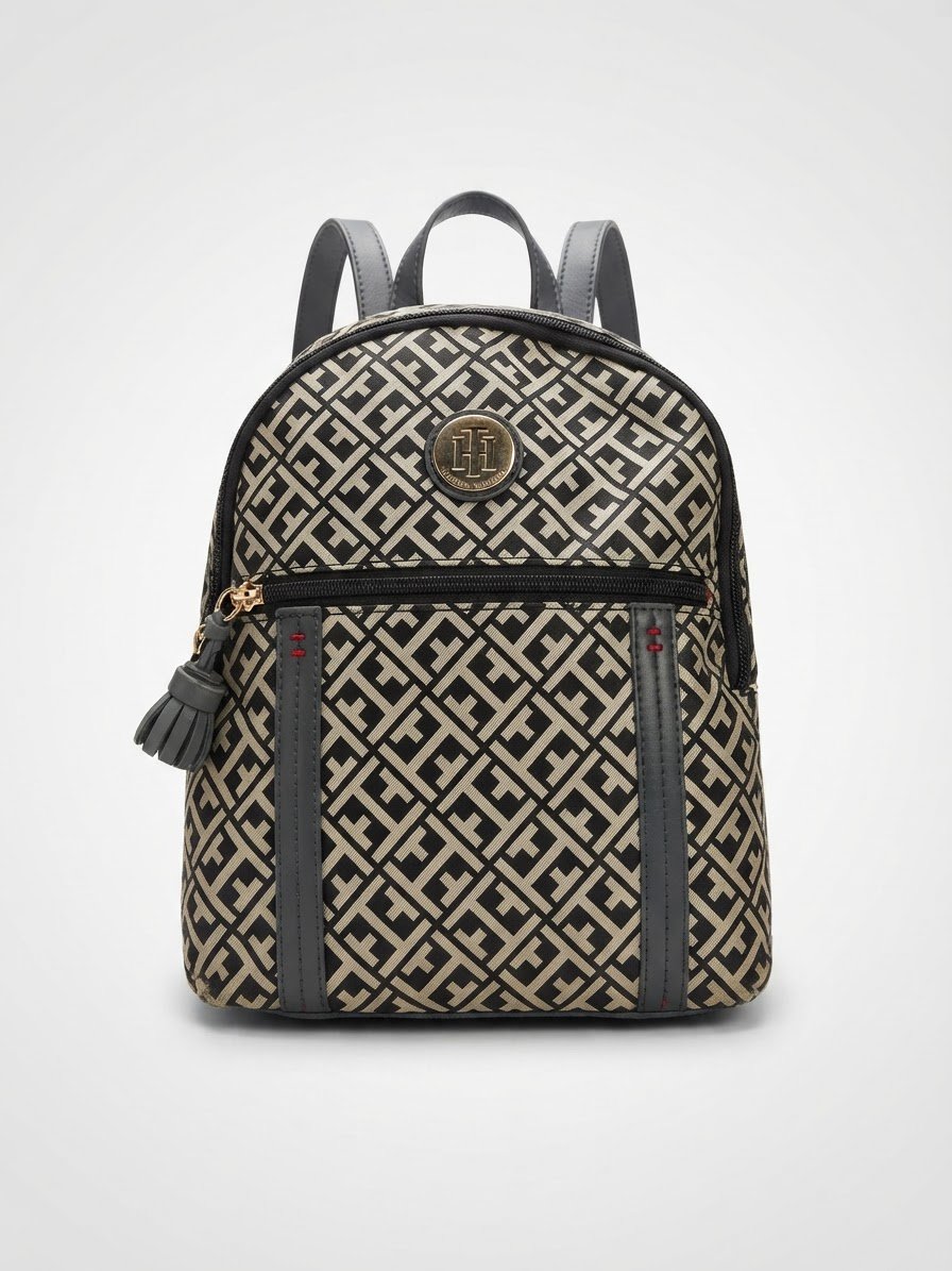 Il s'agit d'un mini sac à dos Tommy Hilfiger en jacquard avec un motif monogramme et une plaque de logo dorée sur le devant