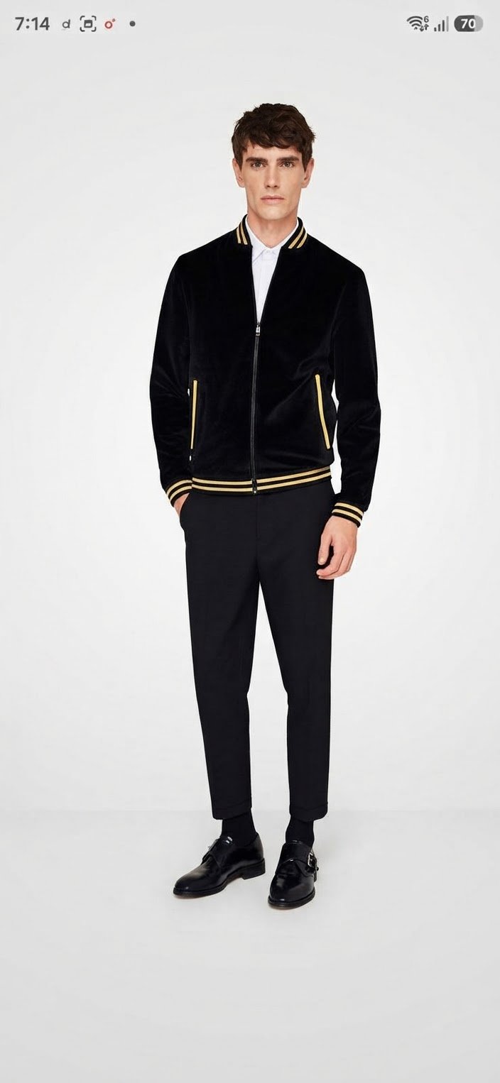 Blouson bomber en velours noir pour homme de la marque Zara Man (souvent repéré sous le nom de Bomber Terciopelo Bordado), doté d'un col, de poignets et d'un bas à rayures dorées et noires. 