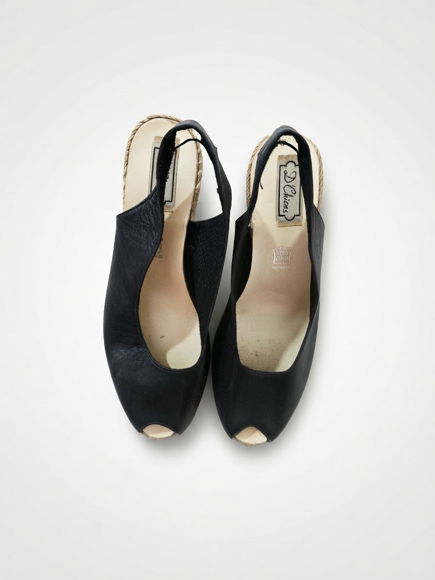 Sandales compensées en cuir noir se distinguent par leur confortable talon en jute tressé d'inspiration espadrille