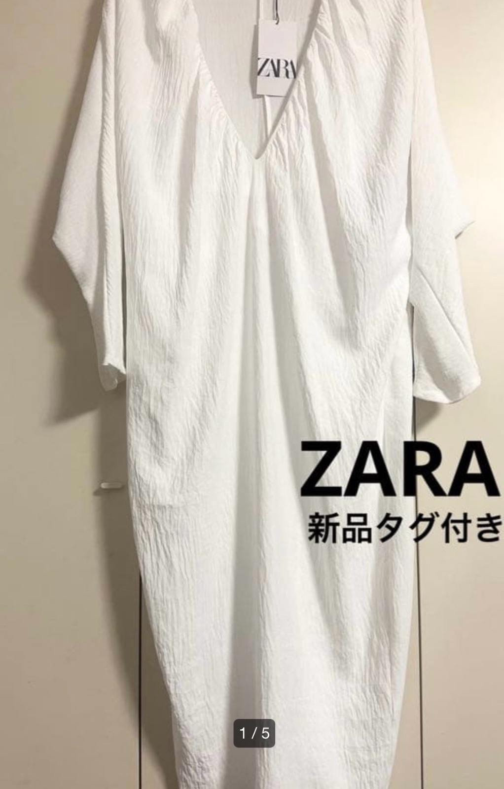 Longue robe caftan blanc cassé de chez ZARA caractérisée par sa matière texturée froissée et son col en V profond.