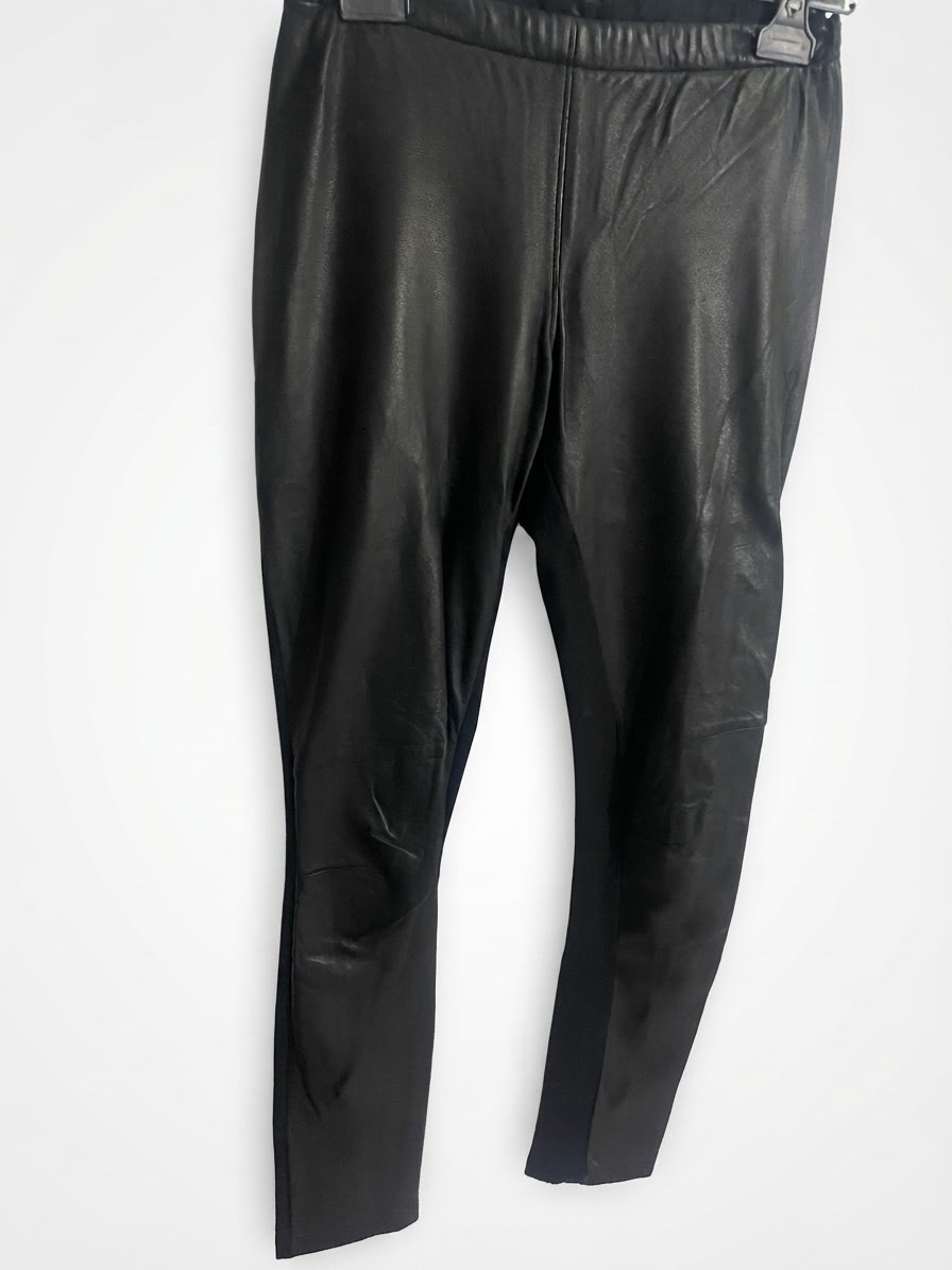 Un legging bi-matière noir pour femme, caractérisé par un devant en cuir stretch lisse et brillant,