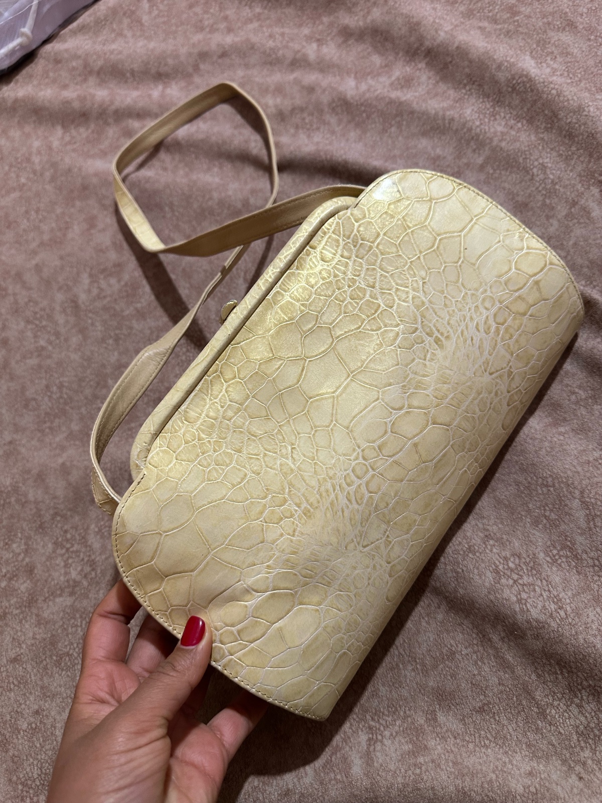 Ou demi-lune, conçu pour transporter des object  Couleur : Le sac est de couleur crème ou jaune pâle, avec une finition légèrement brillante.