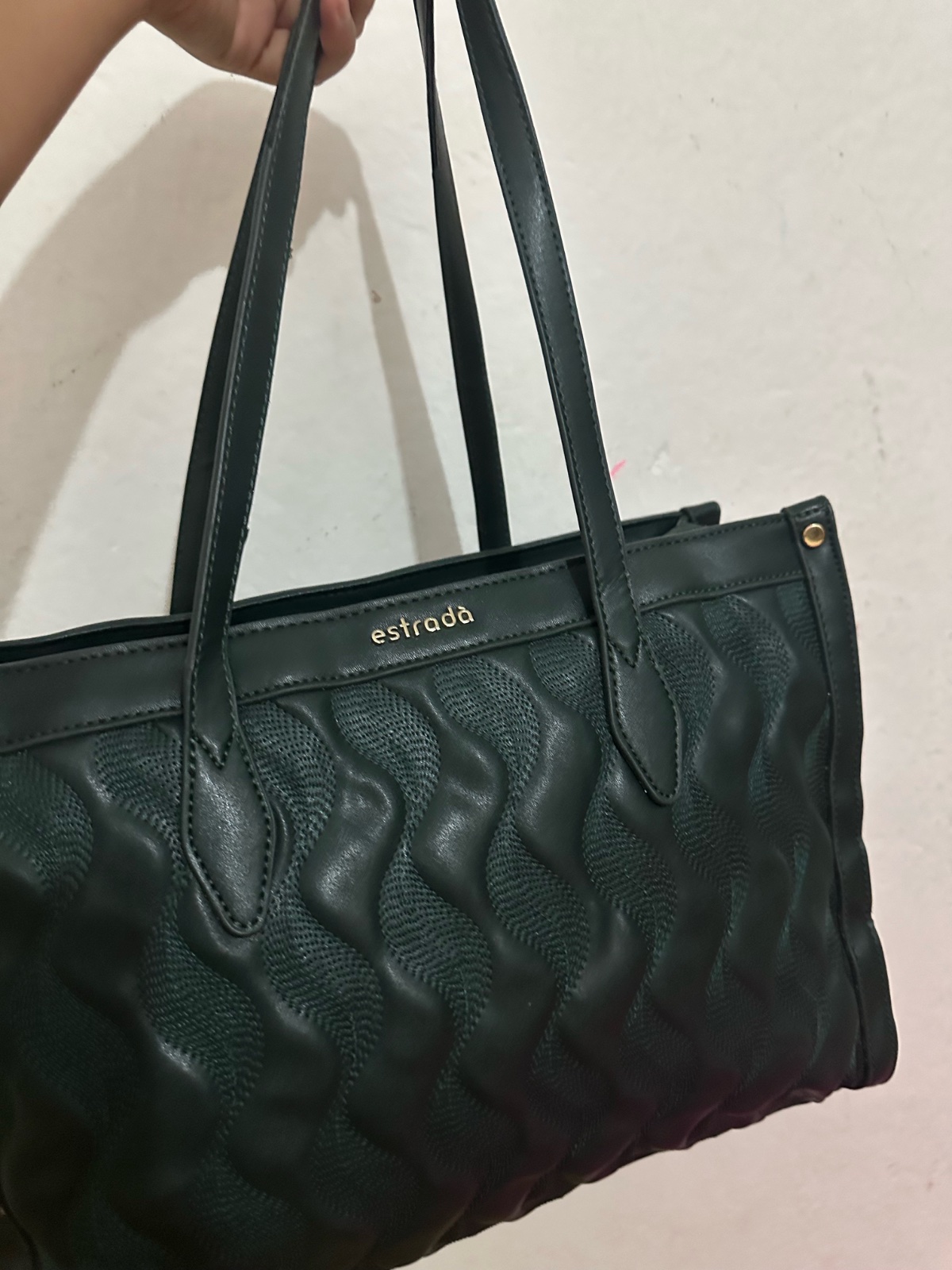 Ce sac à main est un modèle cabas de style cabas matelassé de couleur vert foncé ou noir de la marque estrada.